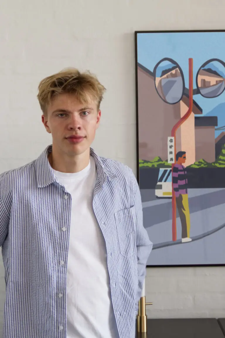 Mathias Aaris står foran plakaten Fuji, som hænger på væggen.